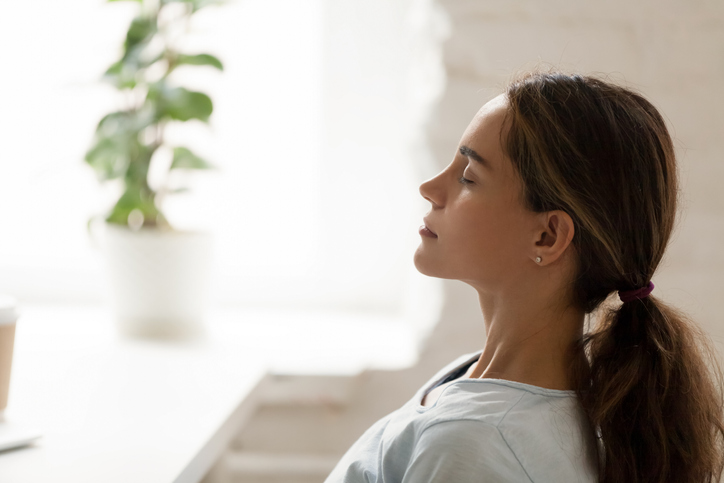 Side view young mixed race woman relaxing with closed eyes.